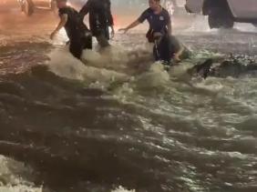 Mưa lớn, nước chảy trôi người và xe máy trên phố ở Đồng Nai