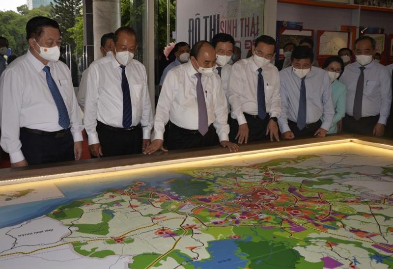 Chủ tịch nước Nguyễn Xuân Phúc (thứ 3 từ trái sang) cùng lãnh đạo cơ quan Trung ương, TP HCM xem sơ đồ quy hoạch huyện Hóc Môn, Củ Chi bên lề hội nghị. Ảnh: Thu Hằng