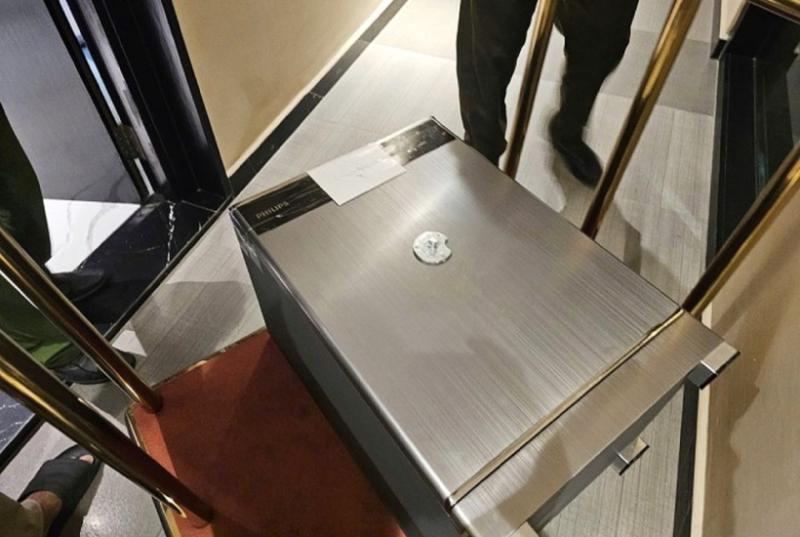 Lực lượng chức năng dùng xe đẩy di chuyển két sắt ra khỏi căn hộ. Ảnh: VnExpress