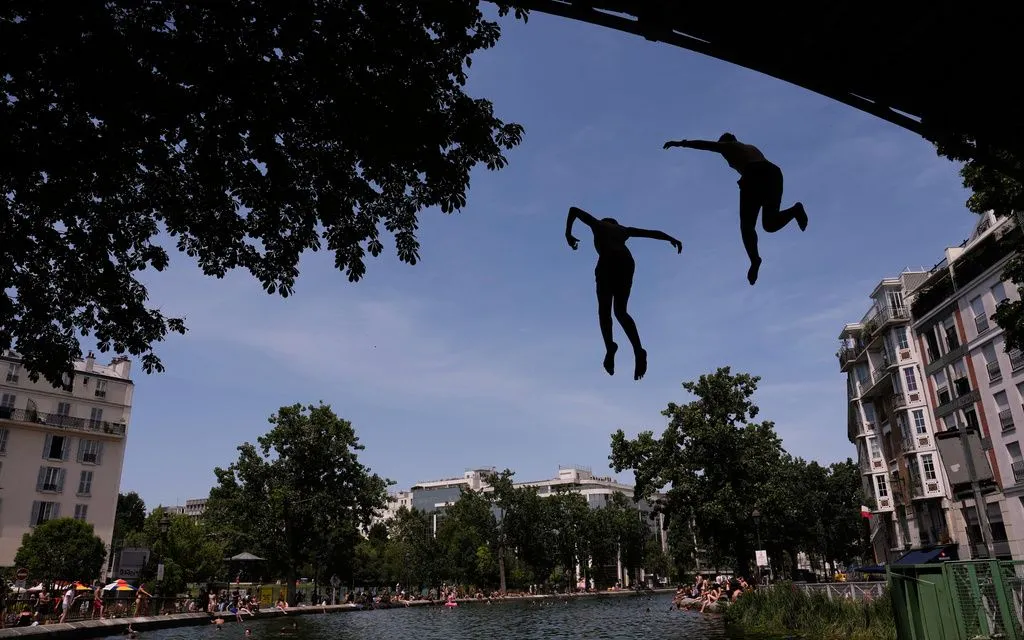 Người dân tắm giải nhiệt tại kênh Saint-Martin ở Paris, ngày 23/6/2026. (Ảnh: AP)