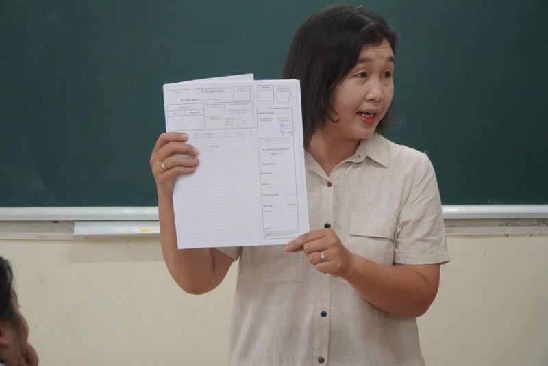 Giám thi coi thi hướng dẫn điền thông tin trên giấy thi cho thí sinh. Ảnh: Chân  Phúc 