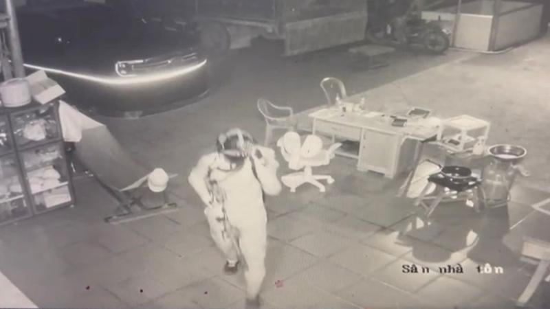 Nam thanh niên đầu đội mũ bảo hiểm loại trùm kín mặt, đeo khẩu trang, đeo ba lô sau lưng và trên tay cầm một vật giống súng dài. Ảnh: VOV.