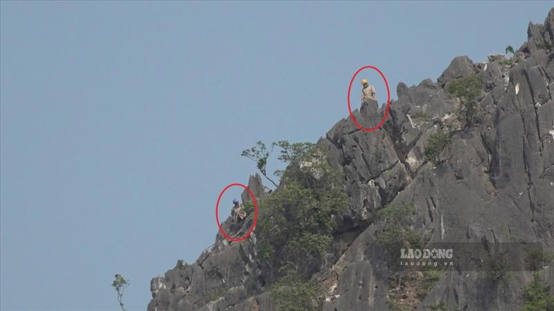Những công nhân (dấu khoanh đỏ) “đu mình” trên đỉnh núi cao mà không có đầy đủ các đồ bảo hộ.